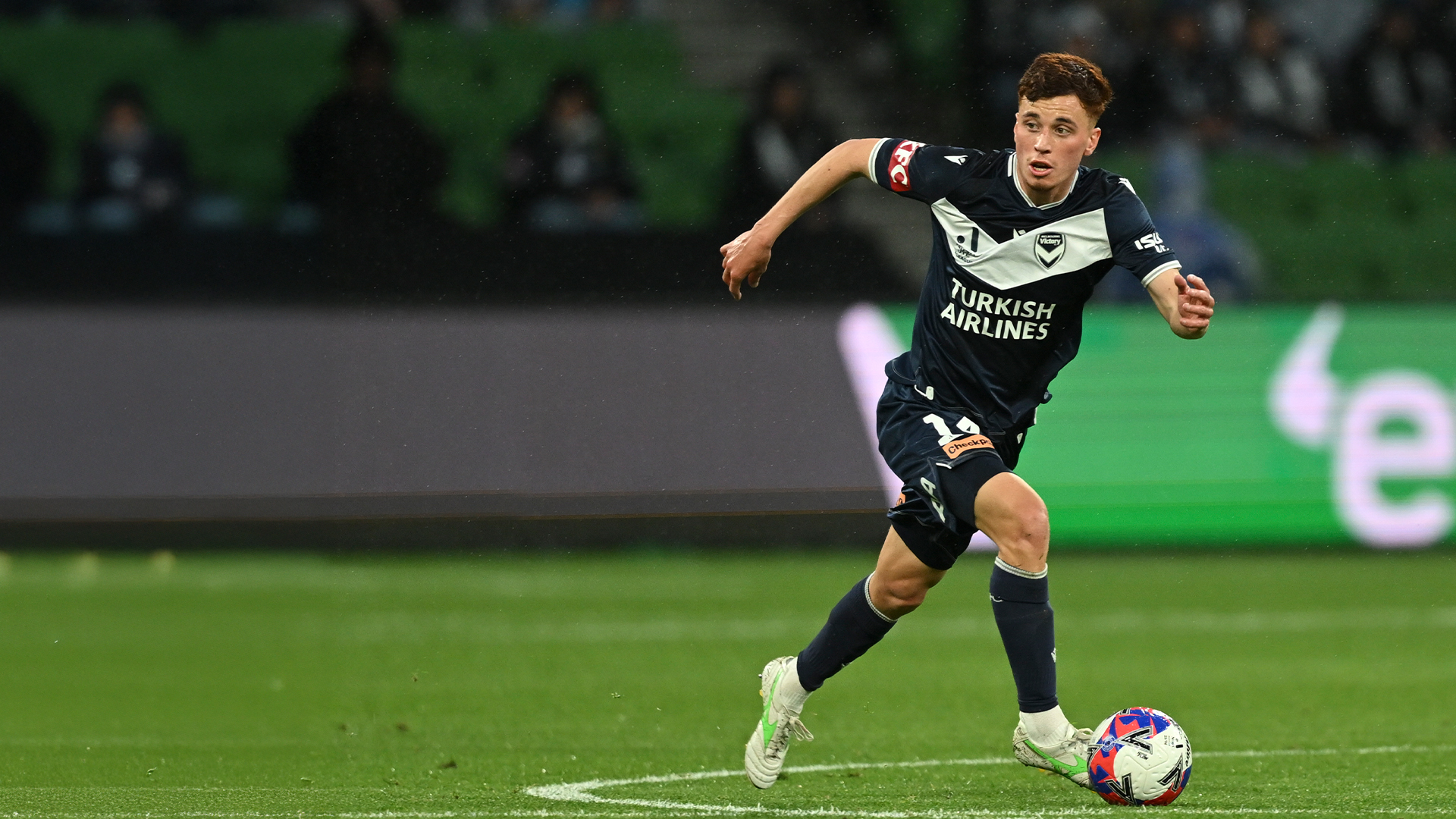 Melbourne Victory footballer dribbling a ball.