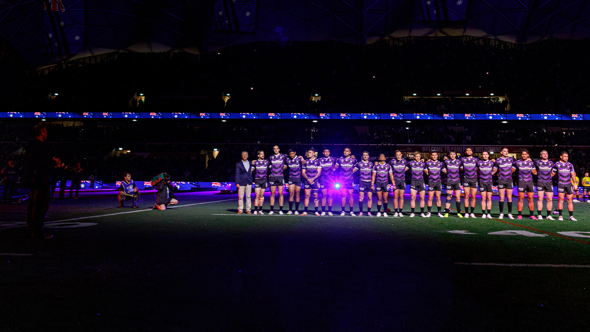 Melbourne Storm rugby league team standing in a line as part of a pre-game ceremony.