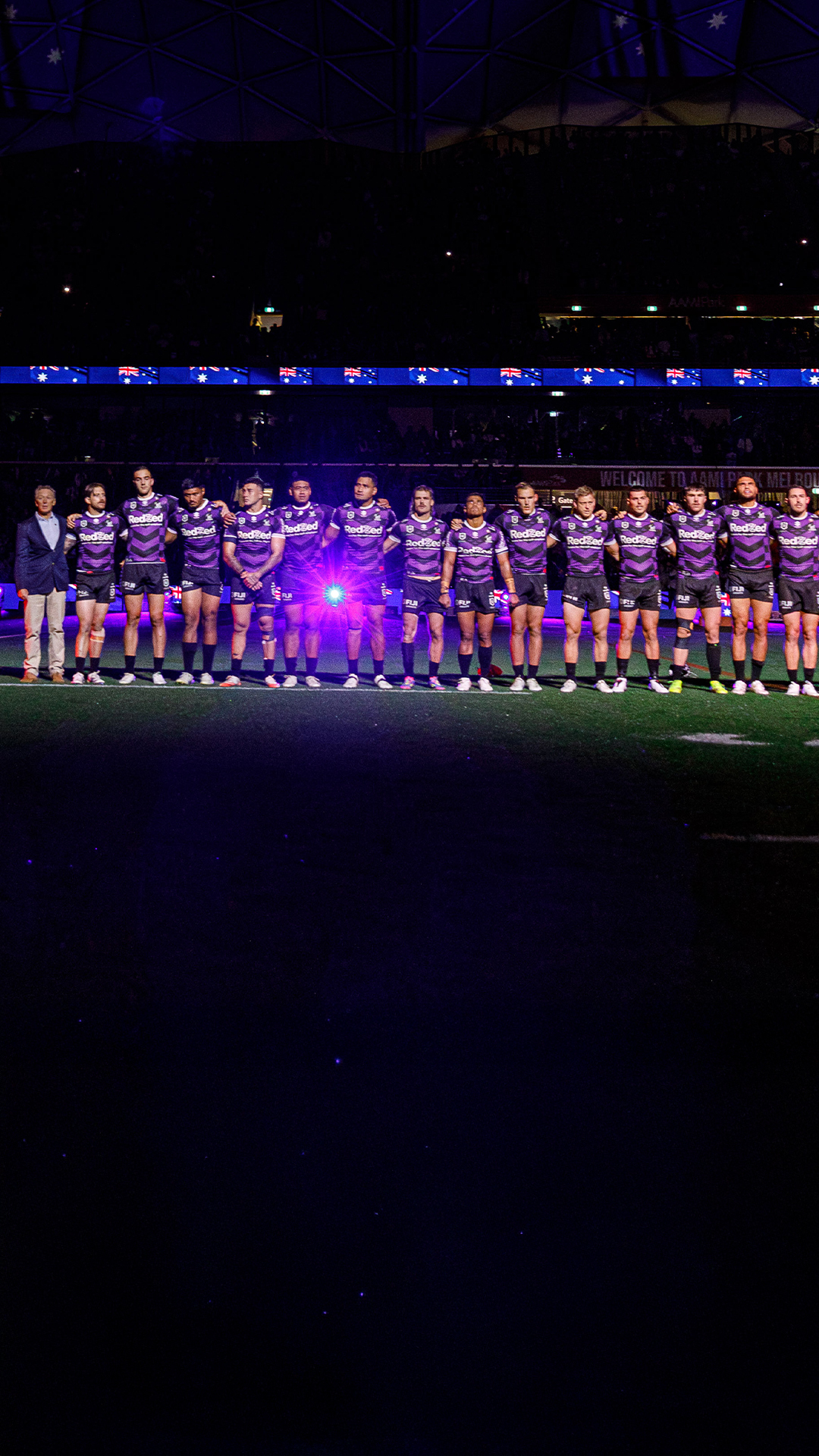 Melbourne Storm rugby league team standing in a line as part of a pre-game ceremony.