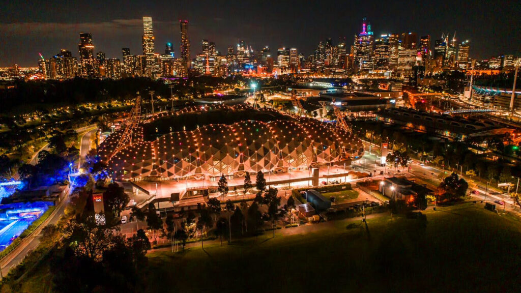 AAMI Park lit up with orange lighting against a city backdrop.